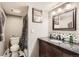 Updated bathroom featuring a modern vanity with decorative backsplash and a shower with black and white curtain at 5490 S Jellison St, Littleton, CO 80123