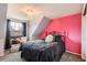Bright bedroom featuring a modern light fixture, black metal bed frame, and vibrant pink accent wall at 5490 S Jellison St, Littleton, CO 80123