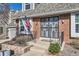 Home's entrance with brick facade, ornate security door, and flag, with steps up to the front door at 5490 S Jellison St, Littleton, CO 80123
