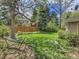 Spacious backyard featuring a lush lawn, mature trees, wooden fence, and a relaxing hammock at 12362 E Vassar Dr, Aurora, CO 80014