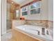 This bathroom boasts a large soaking tub and glass shower with tile surround at 12362 E Vassar Dr, Aurora, CO 80014