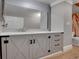 Close-up of a bathroom vanity with light grey cabinets, granite counters, and a large mirror at 12362 E Vassar Dr, Aurora, CO 80014