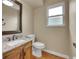 Cozy bathroom with wood floors, granite vanity, and modern toilet at 12362 E Vassar Dr, Aurora, CO 80014