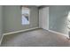 Carpeted bedroom featuring a window providing natural light and a closet with white doors at 12362 E Vassar Dr, Aurora, CO 80014