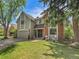 Charming two-story home with a well-maintained front yard and mature trees, featuring mixed siding and brick exterior at 12362 E Vassar Dr, Aurora, CO 80014