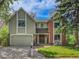 Charming two-story home with a well-maintained front yard and mature trees, featuring mixed siding and brick exterior at 12362 E Vassar Dr, Aurora, CO 80014
