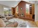 Spacious living room with vaulted ceiling, brick fireplace, and built-in shelving at 12362 E Vassar Dr, Aurora, CO 80014