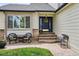 Charming front porch with wicker chairs and decorative wreath on a blue front door at 6836 Edgewood Way, Highlands Ranch, CO 80130