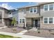 Attractive two-story townhome featuring stone accents, covered entry, and professionally maintained landscape at 1422 Hudson Pl, Longmont, CO 80501