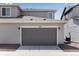 Detached two-car garage with modern gray doors and siding, complemented by a paved driveway at 1422 Hudson Pl, Longmont, CO 80501