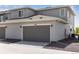 Detached two-car garage featuring modern gray doors, gray siding and a paved driveway at 1422 Hudson Pl, Longmont, CO 80501