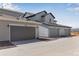 Row of detached garages featuring modern doors, gray siding and smooth paved driveways at 1422 Hudson Pl, Longmont, CO 80501