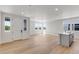 Open floor plan with hardwood floors, white walls, and modern kitchen island providing an airy and spacious living area at 1422 Hudson Pl, Longmont, CO 80501