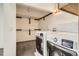 Well-lit laundry room with modern washer and dryer units and ample shelving at 11153 W 17Th Ave # 101, Lakewood, CO 80215