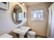 Charming bathroom with an oval mirror, pedestal sink, and a sunlit window at 1065 6Th St, Berthoud, CO 80513