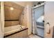 Tiled bathroom with tub/shower and a view into main bedroom at 1065 6Th St, Berthoud, CO 80513