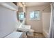 Bright bathroom featuring a pedestal sink, oval mirror, tiled floors, and a window at 1065 6Th St, Berthoud, CO 80513