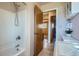 Bathroom view with a shower and tub combo; notice the wood tiled floors and white orchid at 1065 6Th St, Berthoud, CO 80513
