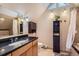 Bright bathroom featuring a skylight, vanity with granite countertop, and tiled walls at 1065 6Th St, Berthoud, CO 80513