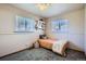 Bright bedroom featuring two windows, plush carpet, and a single bed with stuffed animals at 1065 6Th St, Berthoud, CO 80513