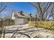 Charming two-story home with a driveway basketball hoop and a beautiful, newly built yellow fence at 1065 6Th St, Berthoud, CO 80513