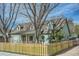View of a charming house featuring dormer windows, a manicured lawn, and wooden fence at 1065 6Th St, Berthoud, CO 80513