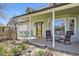 Inviting front porch with rocking chairs, small green table set, and landscaped yard at 1065 6Th St, Berthoud, CO 80513