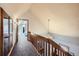 A carpeted hallway leading to an upstairs bedroom with a decorative chandelier at 1065 6Th St, Berthoud, CO 80513
