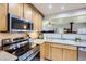 Kitchen with stainless steel oven and microwave, granite counters, and wooden cabinets at 1065 6Th St, Berthoud, CO 80513