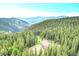 Stunning aerial view of a secluded home nestled among lush green trees and rolling mountains at 1176 Raven Ridge Rd, Idaho Springs, CO 80452