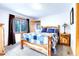 Cozy bedroom includes natural wood furniture, carpet, and serene views of the surrounding nature at 1176 Raven Ridge Rd, Idaho Springs, CO 80452