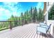 A wooden deck featuring outdoor seating, views of the surrounding trees and blue skies at 1176 Raven Ridge Rd, Idaho Springs, CO 80452