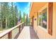 Inviting deck area featuring wood flooring, American flags, and views of the surrounding trees at 1176 Raven Ridge Rd, Idaho Springs, CO 80452