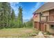 Home exterior displaying garages, multiple decks and a beautiful view of distant mountains and surrounding trees at 1176 Raven Ridge Rd, Idaho Springs, CO 80452