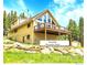 Beautiful mountain chalet with a large deck, surrounded by trees and rocks, offering a perfect retreat at 1176 Raven Ridge Rd, Idaho Springs, CO 80452