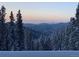 Expansive mountain views at dusk with snow-covered trees creating a winter wonderland at 1176 Raven Ridge Rd, Idaho Springs, CO 80452