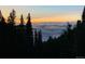 A cloud inversion can be seen from the tree line at dusk with colorful sky and dramatic lighting at 1176 Raven Ridge Rd, Idaho Springs, CO 80452