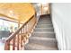 Carpeted staircase ascends to the upper level, showcasing natural wood railing and views into the living space at 1176 Raven Ridge Rd, Idaho Springs, CO 80452