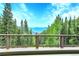 Breathtaking mountain views from a deck with brown railing, surrounded by lush green trees against a stunning blue sky at 1176 Raven Ridge Rd, Idaho Springs, CO 80452