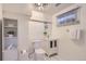 This well-lit bathroom features a new toilet, sink, and shelving unit for storage at 1901 S Adams St, Denver, CO 80210