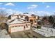 Two-story home with a three-car garage and a snow-covered yard. American flag displayed at 8932 Tuscany Ln, Highlands Ranch, CO 80130