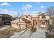 Two-story home with a three-car garage and a snow-covered yard. American flag displayed at 8932 Tuscany Ln, Highlands Ranch, CO 80130