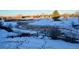 Snowy backyard with wooden fence and small bridge in background at 8932 Tuscany Ln, Highlands Ranch, CO 80130