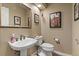 Elegant powder room with pedestal sink, toilet, and framed artwork at 8932 Tuscany Ln, Highlands Ranch, CO 80130