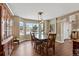 Formal dining room with hardwood floors, bay window, and a glass-top table at 8932 Tuscany Ln, Highlands Ranch, CO 80130