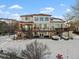 Two-story home with large deck and snowy backyard at 8932 Tuscany Ln, Highlands Ranch, CO 80130