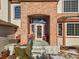 Brick front porch with seating area, arched entryway, and large windows at 8932 Tuscany Ln, Highlands Ranch, CO 80130