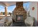 Outdoor patio with stone fireplace and seating area at 8932 Tuscany Ln, Highlands Ranch, CO 80130