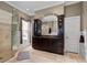 Modern bathroom featuring a glass shower, dual sinks, dark cabinetry, and decorative floor tiles for an elegant touch at 728 N Ogden St, Denver, CO 80218
