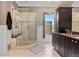 Bathroom with a walk-in shower, marble tiling, dark vanity and a window that provides natural lighting at 728 N Ogden St, Denver, CO 80218